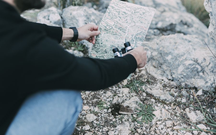 Hiker pausing on a trail to read a map